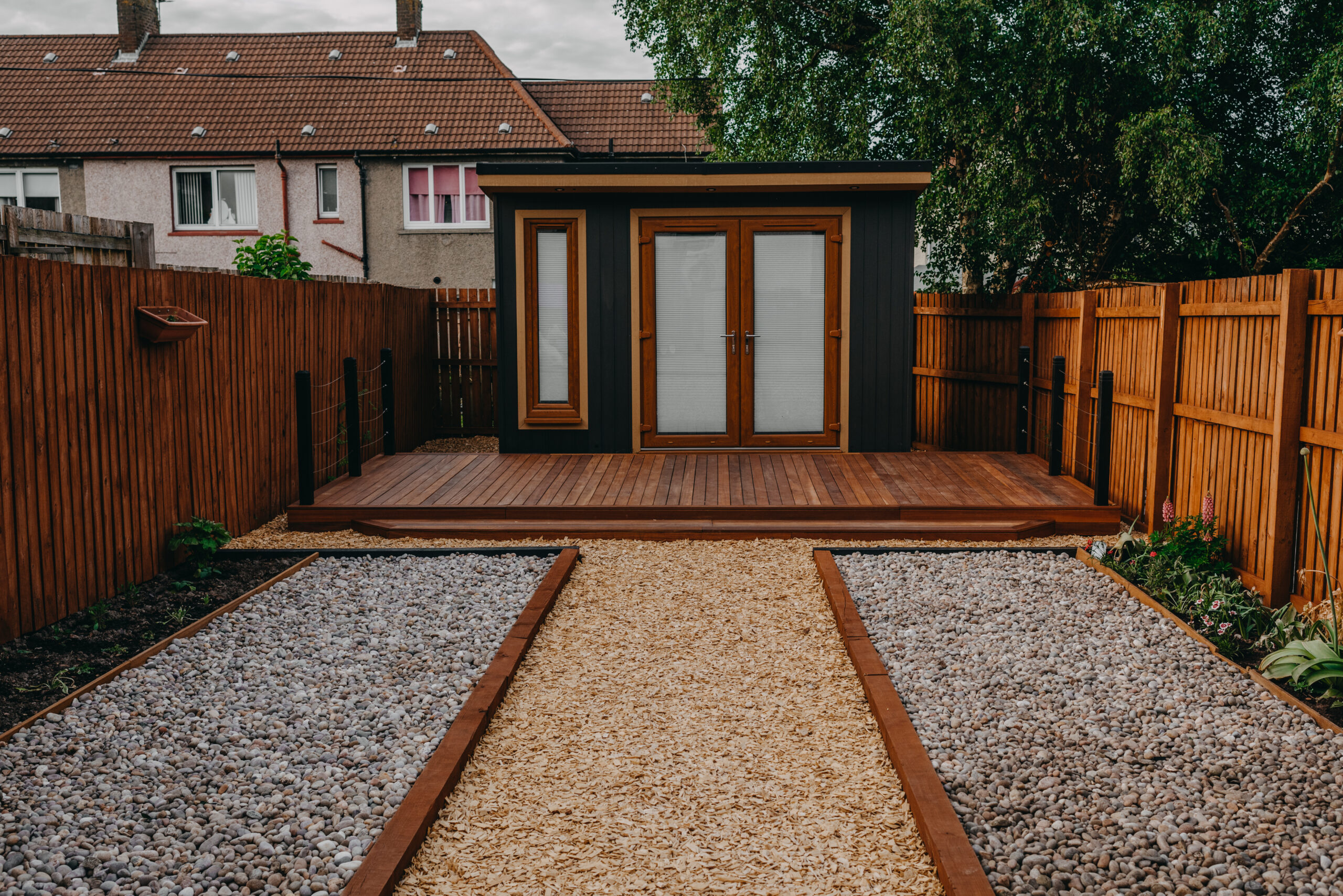 Timber decking norwich surrounding a garden rooms norwich by green machine